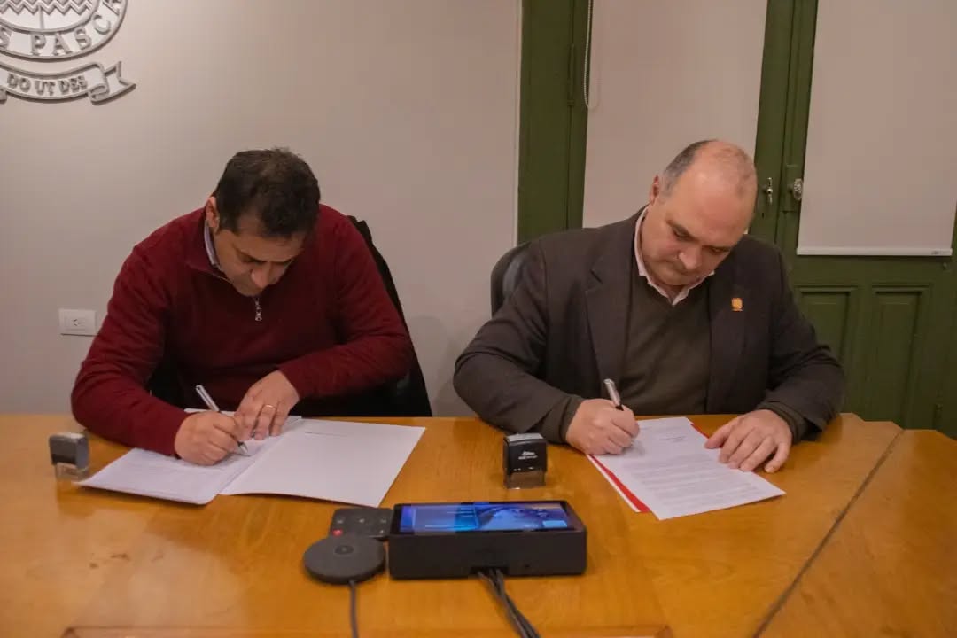 Daniel Spadoni firmando con el Rector de la UBP